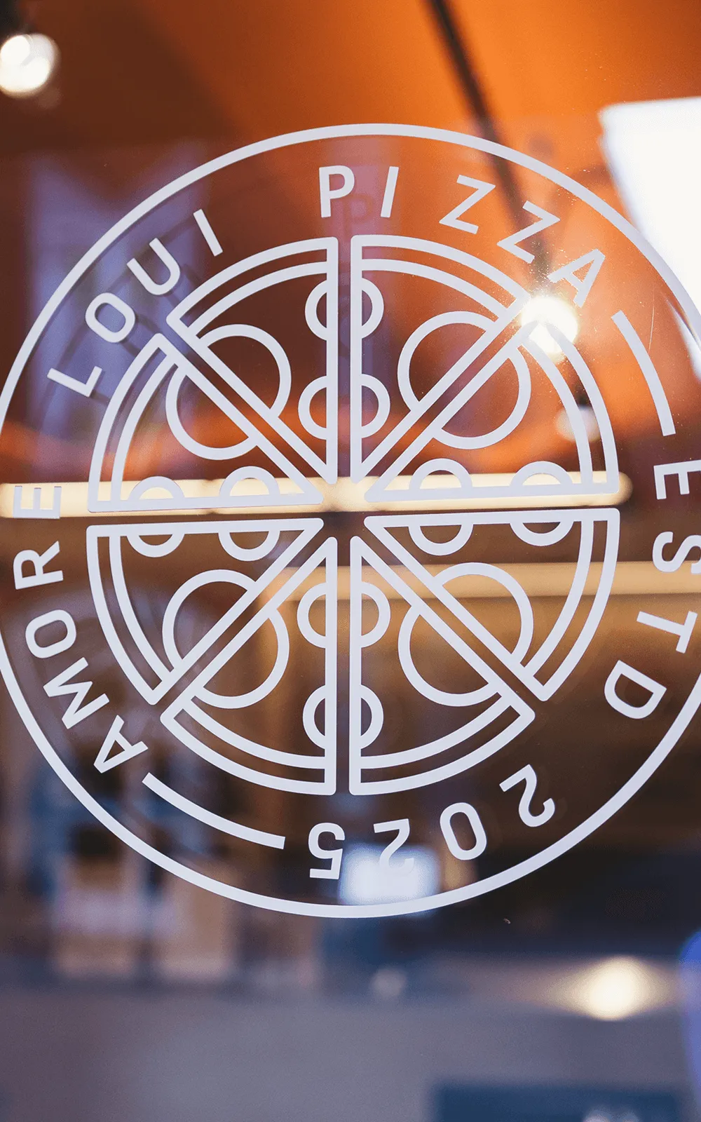 Das Amore Loui Emblem auf einer Fensterscheibe bei Nacht
